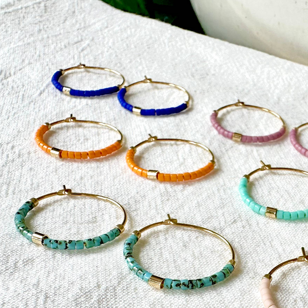 Small beaded hoop earrings by Ocean Breakup featuring colorful beads and gold-tone hoops for a vibrant accessory.