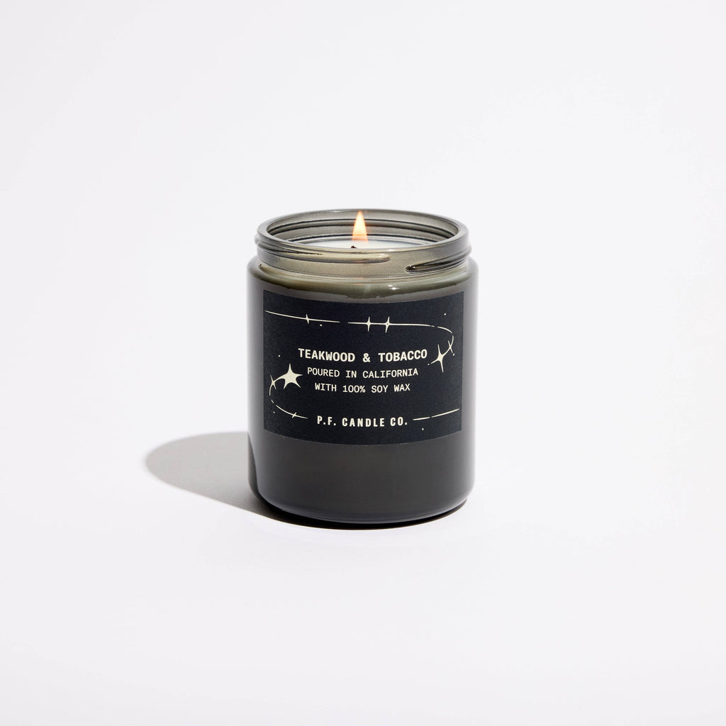 P.F. Candle Co. Teakwood & Tobacco Celestial Collection candle in a glass jar, showcasing a warm, earthy candle with wooden and tobacco scent.