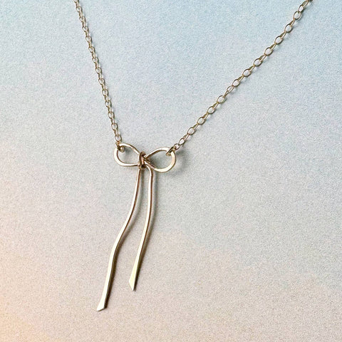 Freshie & Zero bow necklace featuring a delicate fabric bow on a silver chain, stylish and feminine jewelry accessory.