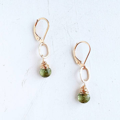 Freshie & Zero peridot bay gemstone drop earrings with gold hooks and vibrant green gemstones hanging elegantly.