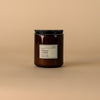 Dilo No. 05 Coconut + Vetiver candle with a lit wick, showcasing a sleek glass container and a calming, aromatic scent.