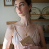 Fox & Acorn vintage-style enamel locket necklace by Fable England featuring intricate fox and acorn designs on a delicate chain