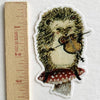 Hedgehog violinist illustrated vinyl sticker by Jahna Vashti, featuring a cute hedgehog playing the violin on a colorful background.