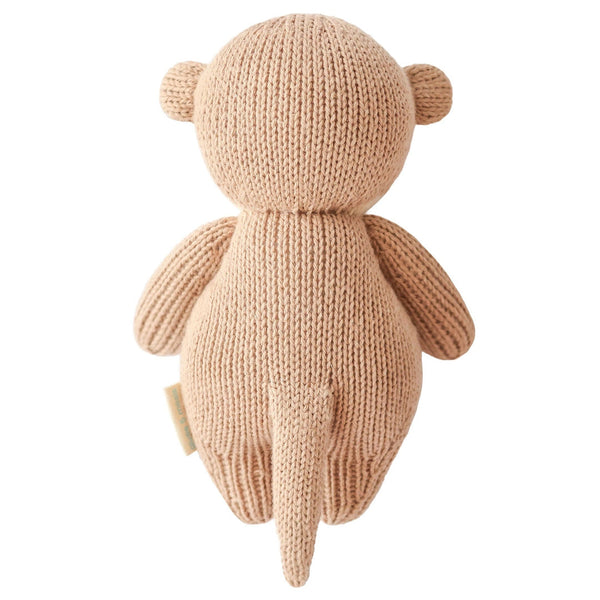Hand-knit baby otter doll by Cuddle + Kind, soft and adorable plush toy for children, featuring detailed stitching and a cute expression.