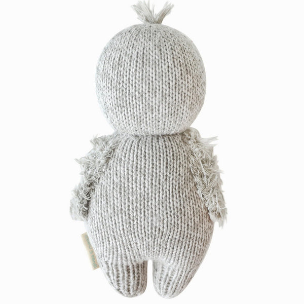 Mini hand-knit penguin doll by Cuddle + Kind, soft baby plush toy with detailed black and white penguin features.