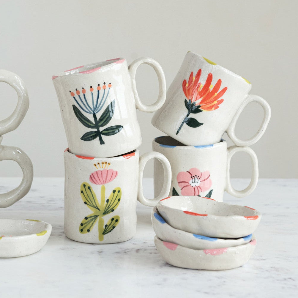 Set of ceramic mugs with floral designs on a light background