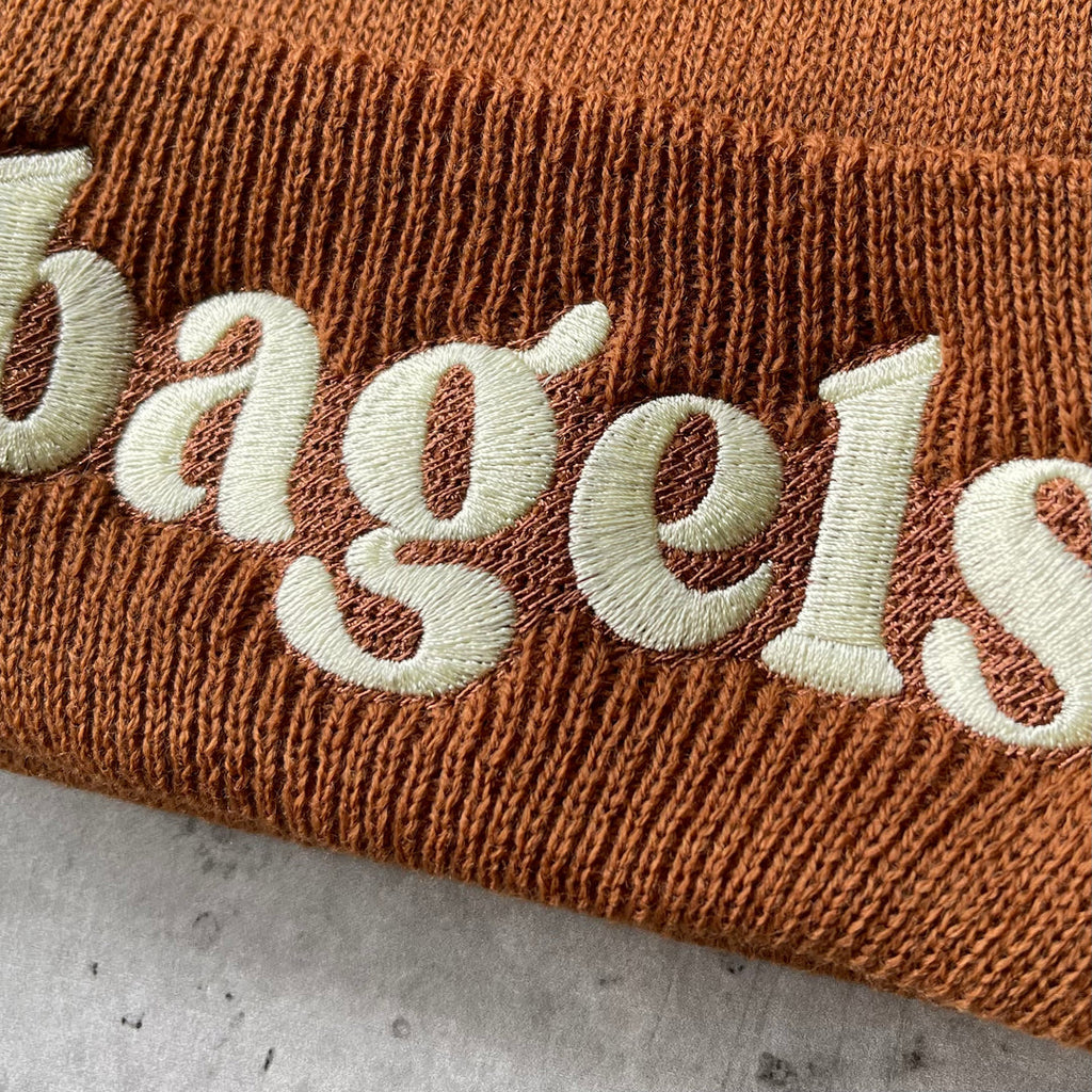 The Silver Spider Bagels embroidered beanie winter hat with colorful bagel design, knit fabric, and snug fit for cold weather.