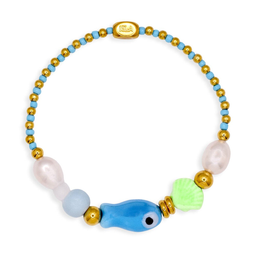 Colorful beaded bracelet with a blue fish charm on a white background