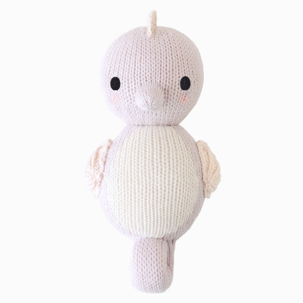 Mini hand-knit baby doll by Cuddle + Kind featuring soft yarn and detailed facial features, perfect for gentle play and cuddling.