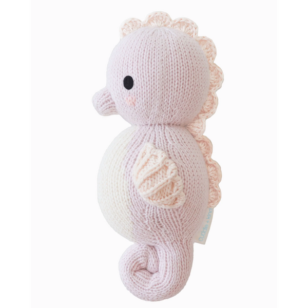 Mini hand-knit baby doll by Cuddle + Kind featuring soft yarn, adorable facial details, and tiny limbs, perfect for gentle play.