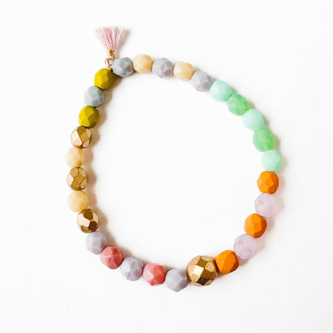 Colorful stretchy beaded bracelet with tiny tassel from Nest Pretty Things, featuring vibrant beads and delicate tassel accents.