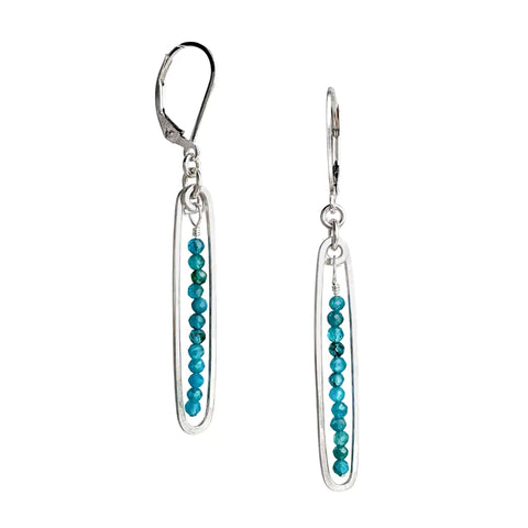 Freshie & Zero Lyric Earrings with sparkling blue topaz stones, showcasing elegant dangle design on a white background.