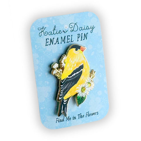 Goldfinch enamel pin by Katie Daisy, vibrant botanical-themed accessory featuring a detailed goldfinch bird design.