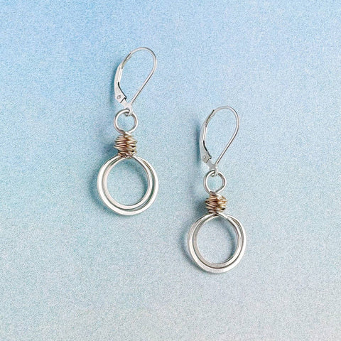Gold swirl loops earrings by Freshie & Zero featuring elegant, circular design with a shiny gold finish.