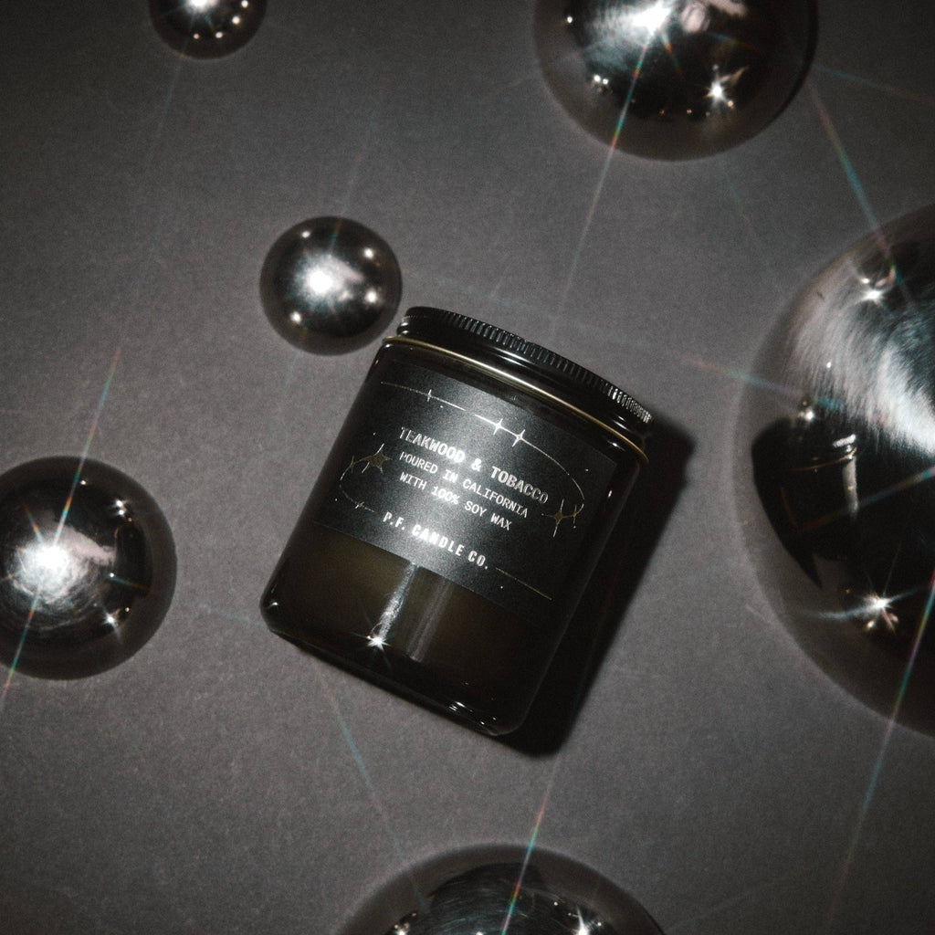 P.F. Candle Co. Teakwood & Tobacco Celestial Collection candle with a natural wax finish and minimalist label design.