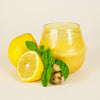 Golden Basil & Mint 18 oz Rowan glass candle from Elum Designs, showing the candle with a lit flame in a clear glass holder.