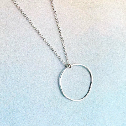 Freshie & Zero Orbita necklace featuring a delicate chain with a spherical pendant, stylish jewelry accessory.