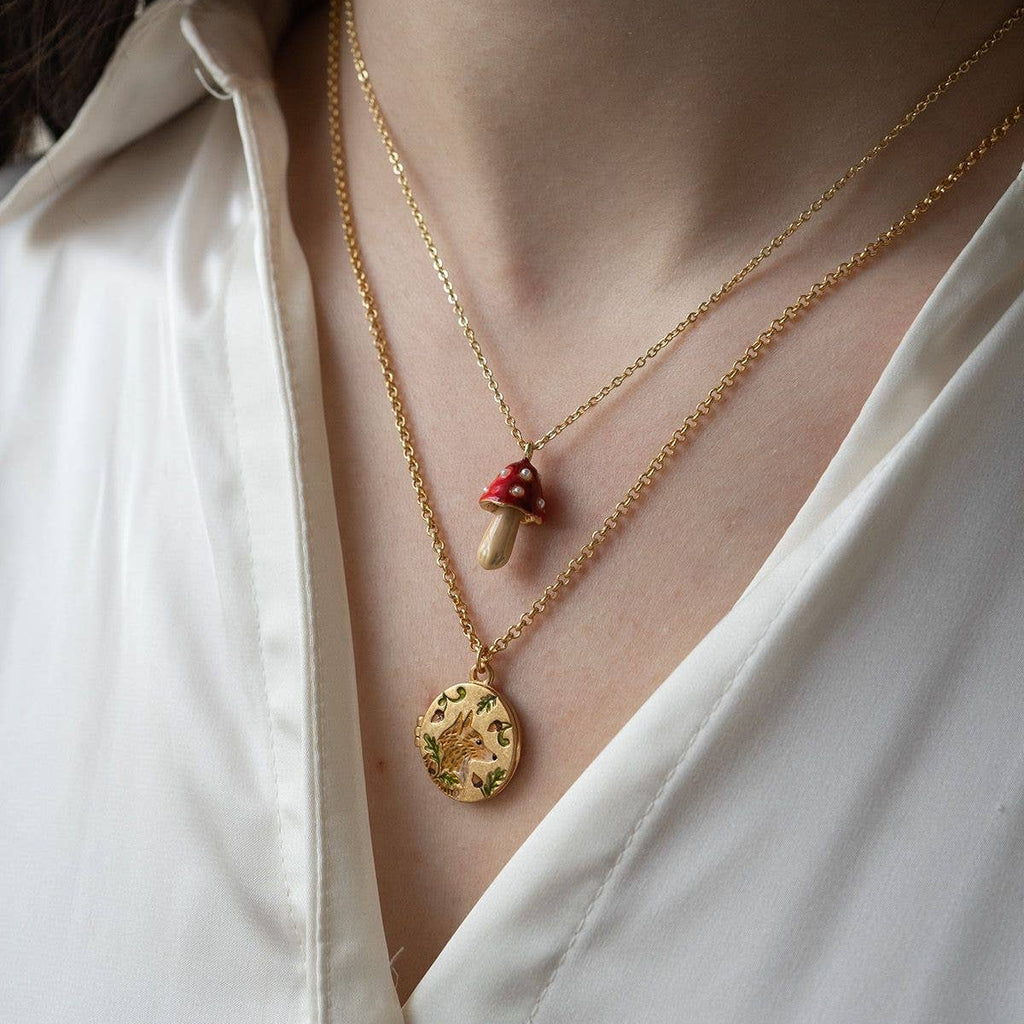 Vintage-style enamel locket necklace by Fable England featuring intricate fox and acorn designs on a delicate chain.