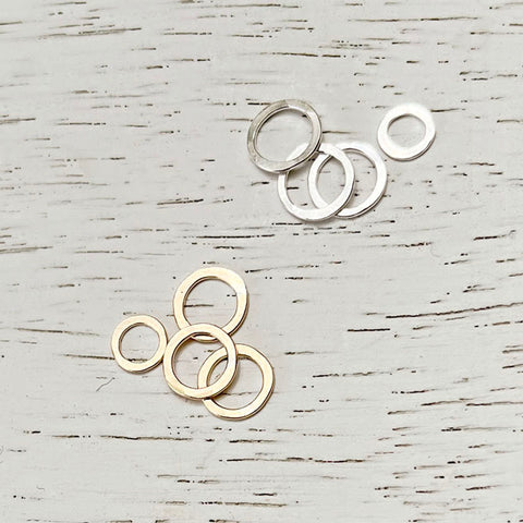 Close-up of a Freshie & Zero necklace featuring an extra cluster ring pendant with layered silver designs.