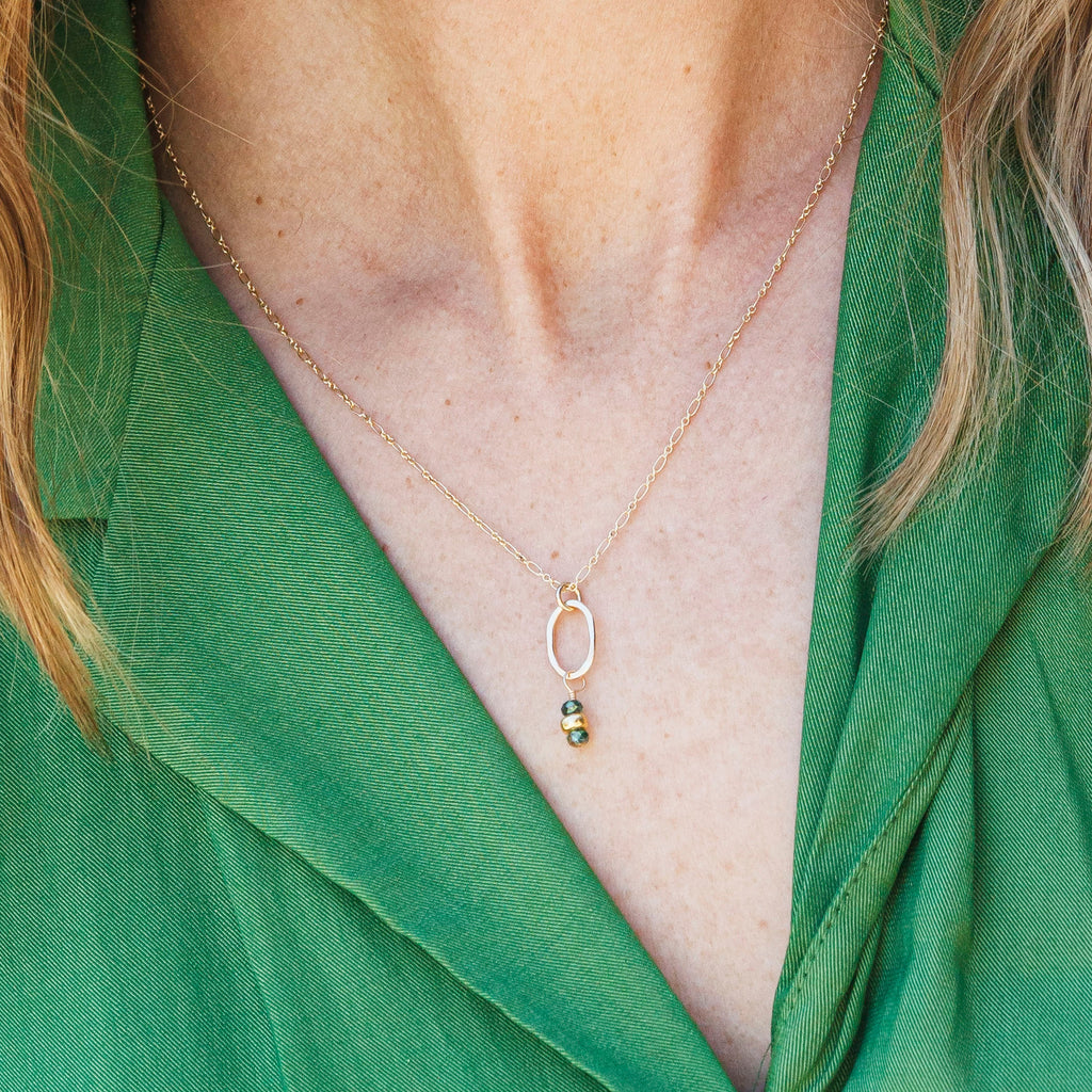 handamde Gold necklace with a tiny pendant with green crystals