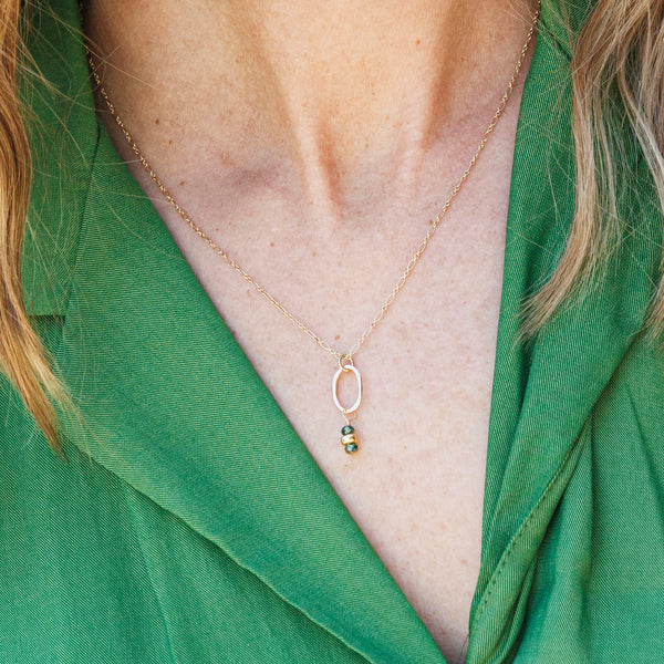 handamde Gold necklace with a tiny pendant with green crystals