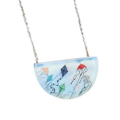 Hand-painted pendant necklace by Fernworks featuring a colorful kite design, showcasing intricate detail and vibrant craftsmanship.
