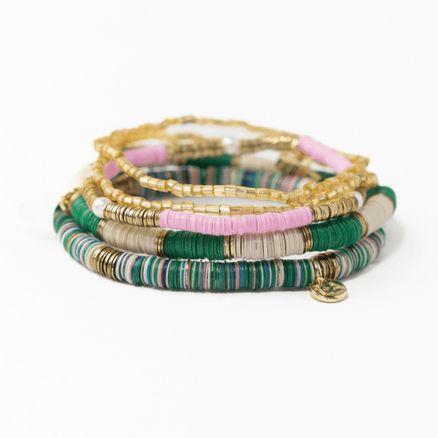 Stack of five Ink + Alloy bracelets featuring green and pink beads, including Grace emerald and pink bracelet designs.