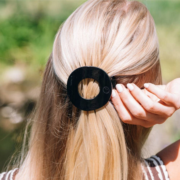 Jet-black TELETIES Flat Circle Hair Clip in medium size, showcasing its smooth, flat circular design for stylish hair accessory.