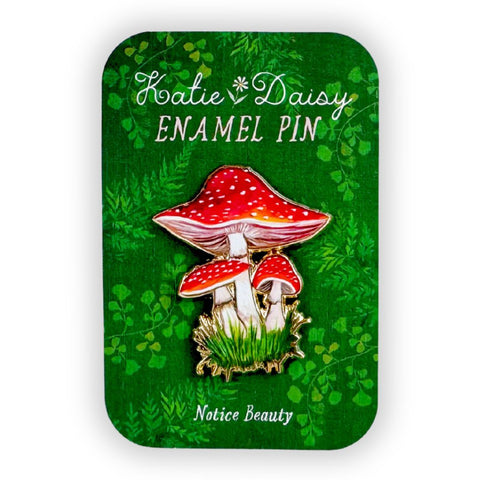 A close-up of a Katie Daisy enamel pin featuring a detailed Amanita mushroom design, perfect for accessories and pin collectors.