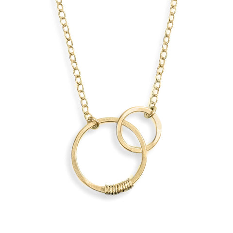 Silver sisters necklace by Freshie & Zero featuring interlinked heart-shaped pendants on a delicate chain.