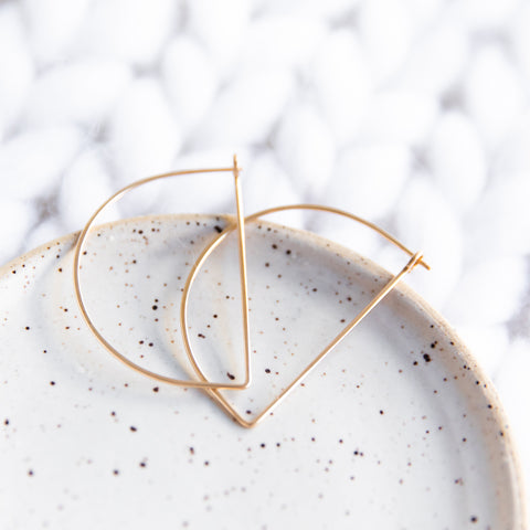 Large gold half moon hoop earrings by Freshie & Zero, showcasing their minimalist and elegant design.