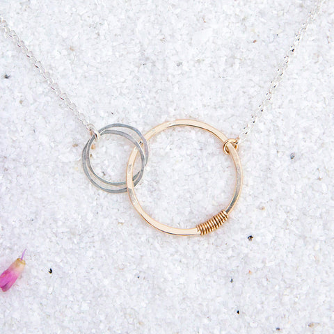 Freshie & Zero love necklace for mother of two, featuring two interlocking heart-shaped pendants on a delicate chain.